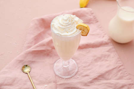 Glass of tasty banana milkshake on color backgroundの写真素材