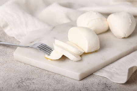 Mozzarella cheese with fork on boardの写真素材