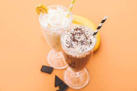 Glasses of tasty milkshakes on color backgroundの写真素材