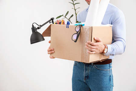 Fired man with personal things on light backgroundの写真素材