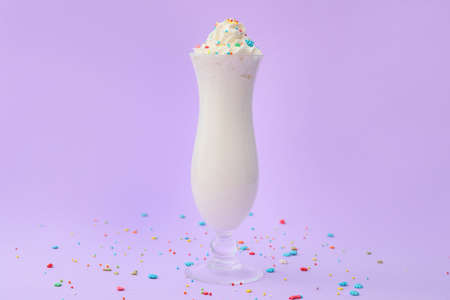 Glass of tasty milkshake on color backgroundの写真素材