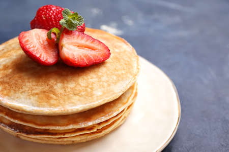 Stack of tasty sweet pancakes on dark background