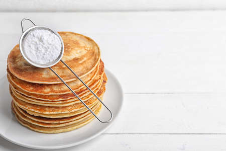 Stack of tasty sweet pancakes on white table