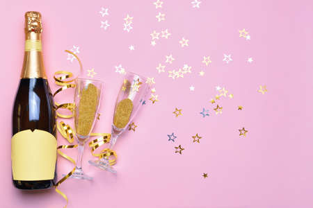 Bottle of tasty champagne and glasses with party decor on color backgroundの写真素材