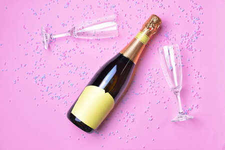 Bottle of tasty champagne and glasses on color backgroundの写真素材