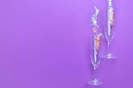 Glasses for champagne with glitters on color backgroundの写真素材