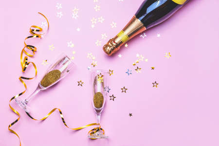 Bottle of tasty champagne and glasses with party decor on color backgroundの写真素材