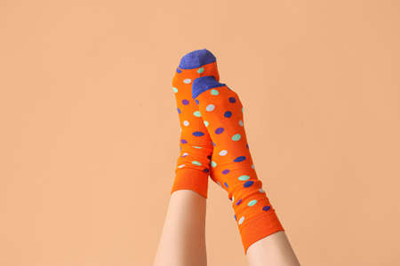 Legs of young woman in socks on color backgroundの写真素材