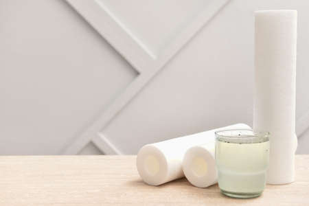 Glass of dirty water and filters on tableの写真素材