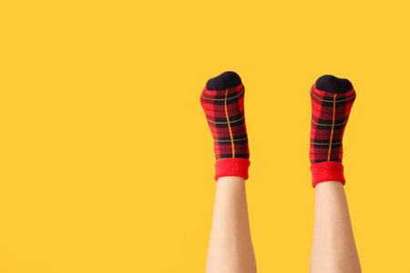 Legs of young woman in socks on color backgroundの写真素材