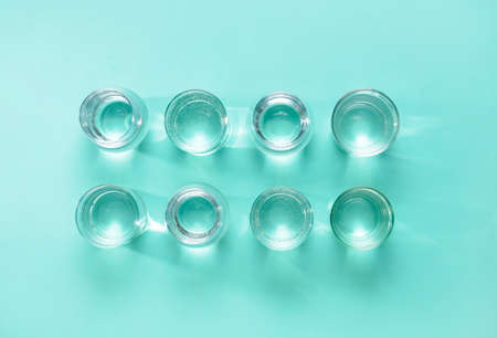 Glasses of clean water on color background