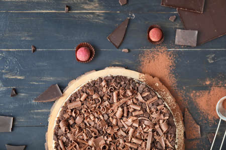 Tasty chocolate cheesecake on dark table