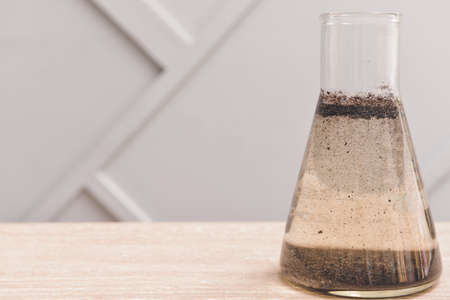 Flask with dirty water on tableの写真素材