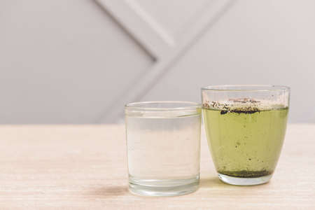 Glasses with clean and dirty water on table