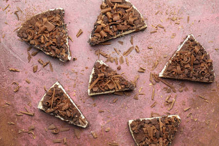 Pieces of tasty chocolate cheesecake on color background