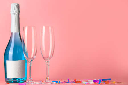 Bottle of tasty champagne and glasses on color background