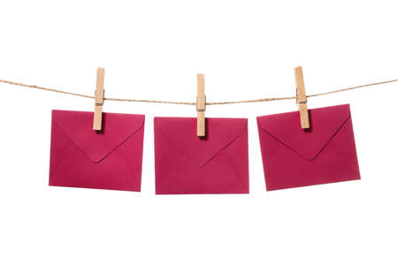 Paper envelopes hanging on rope against white backgroundの写真素材