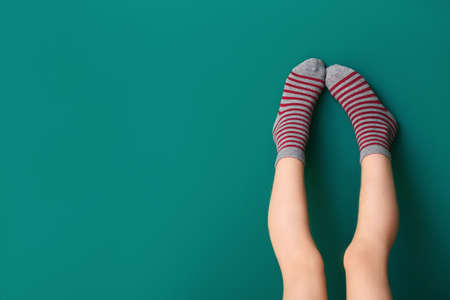 Legs of little girl in socks on color backgroundの写真素材
