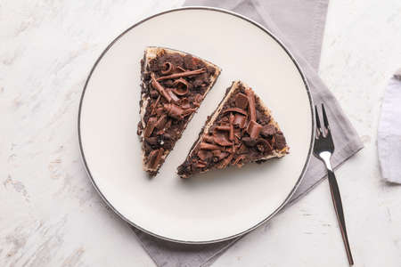 Plate with pieces of tasty chocolate cheesecake on table