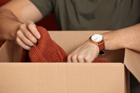Young man unpacking box with new clothes at home, closeupの写真素材