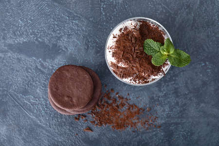 Tasty chocolate cookies with dessert in glass on dark backgroundの写真素材