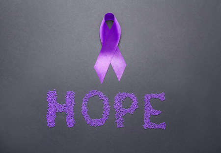 Violet ribbon and word HOPE on dark background. Domestic violence conceptの写真素材