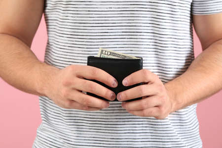 Man with purse on color background, closeup