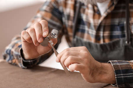 Jeweler examining gemstone in workshop, closeup
