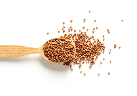 Spoon with raw buckwheat on white backgroundの写真素材