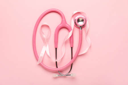 Pink ribbon with stethoscope on color background. Breast cancer awareness conceptの写真素材