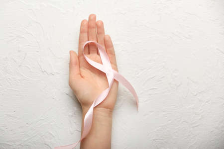 Female hand with pink ribbon on white background. Cancer awareness conceptの写真素材