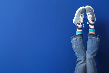Legs of young woman on color backgroundの写真素材