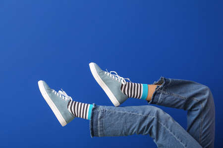 Legs of young woman on color backgroundの写真素材