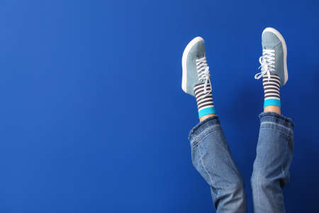 Legs of young woman on color backgroundの写真素材