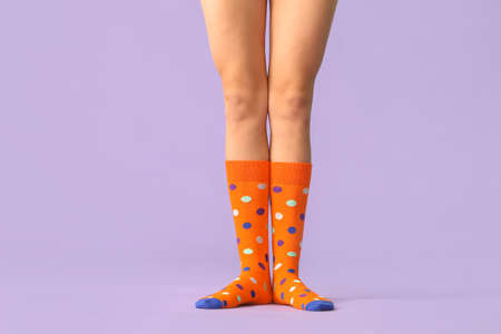 Legs of young woman in socks on color backgroundの写真素材