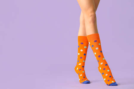 Legs of young woman in socks on color backgroundの写真素材