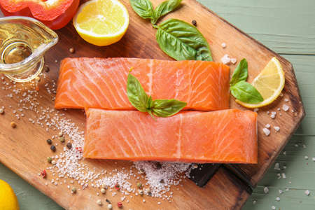 Raw salmon fillet with oil and spices on tableの写真素材