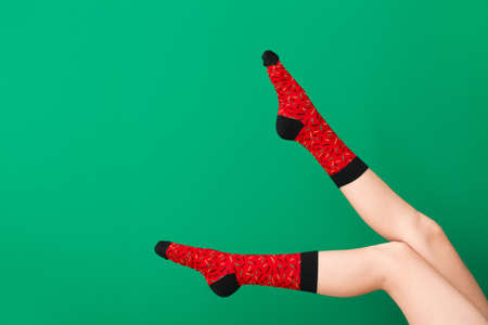 Legs of young woman in socks on color backgroundの写真素材
