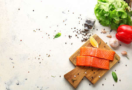 Raw salmon fillet with vegetables and spices on white backgroundの写真素材