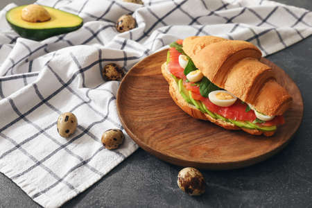 Tasty croissant sandwich on tableの写真素材