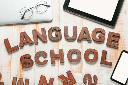Composition with text LANGUAGE SCHOOL on wooden background