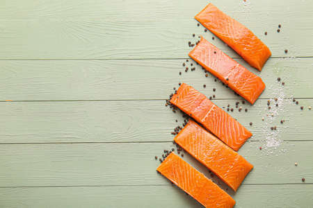 Raw salmon fillet with spices on wooden backgroundの写真素材