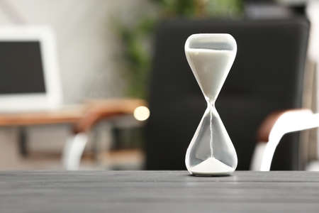 Hourglass on table in office. Time management concept