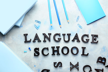 Composition with stationery and text LANGUAGE SCHOOL on color backgroundの写真素材