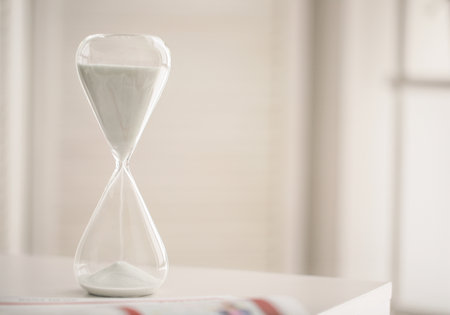 Hourglass on table in office. Time management conceptの写真素材