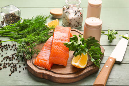 Raw salmon fillet with herbs and spices on tableの写真素材