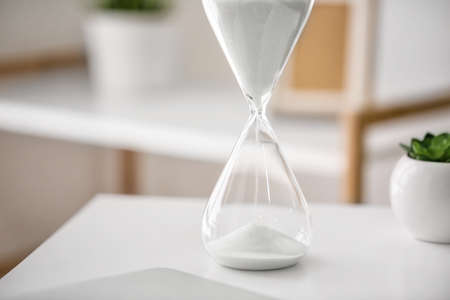 Hourglass on table in office. Time management concept