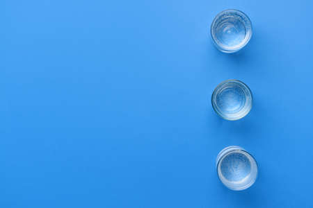 Glasses of clean water on color backgroundの写真素材