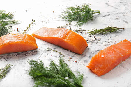 Raw salmon fillet with spices and herbs on white backgroundの写真素材