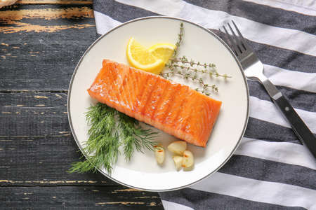 Cooked salmon fillet with herbs on tableの写真素材